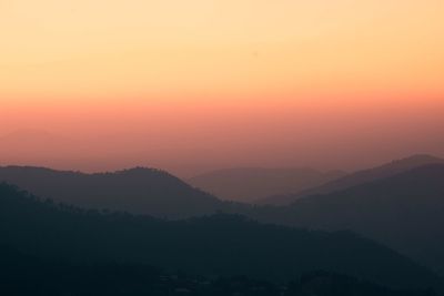 Scenic view of silhouette mountains against sky during sunset