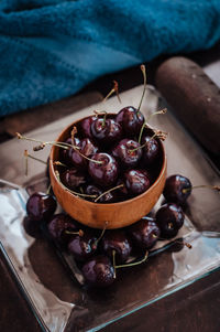 Close-up of cherry fruits in a wooden bowl on table