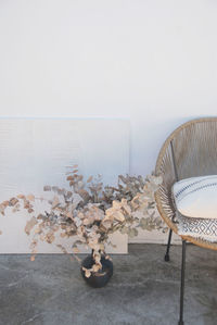 Close-up of empty chair on table against wall