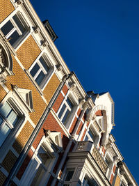 Low angle view of buildings against clear blue sky