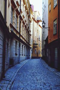 Empty alley amidst buildings in city