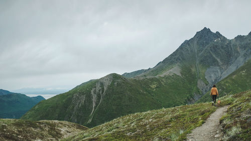 Rear view of man on mountains against sky