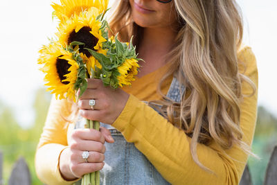 Midsection of woman holding flower bouquet