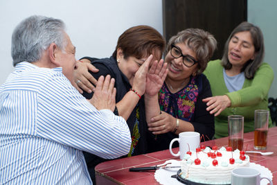 Portrait of smiling friends having food at home