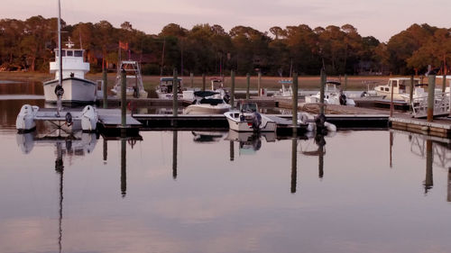 Boats moored at harbor against sky