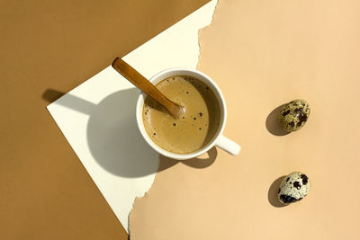 High angle view of coffee on table with quail eggs with hard shadow