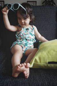 Cute girl sitting on sofa at home