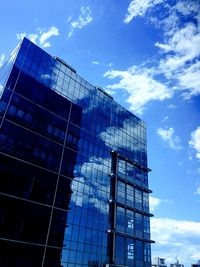 Low angle view of modern building against blue sky