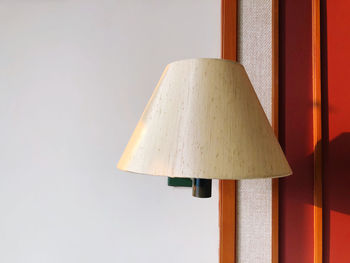 Close-up of lamp against wall at home