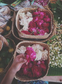 Close-up of hand holding bouquet of red roses