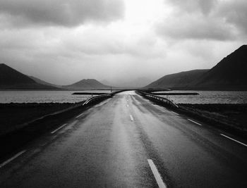 Road leading towards mountain against sky