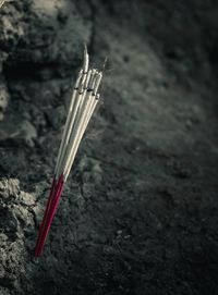 High angle view of cross on rock against wall