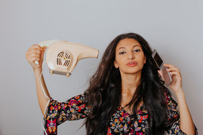 Portrait of beautiful young woman standing against wall