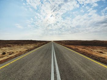 Road passing through landscape against sky