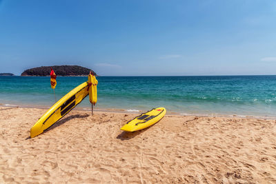 Yellow umbrella on beach against sky