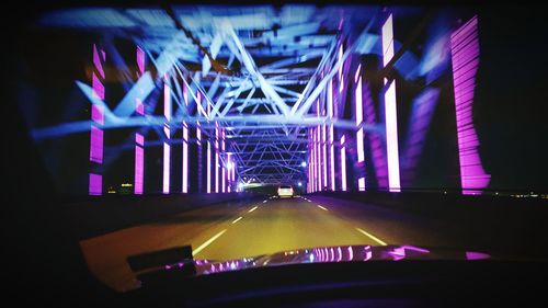 Illuminated bridge in city at night