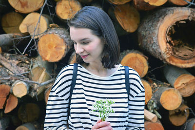 Full length of woman standing on wooden logs