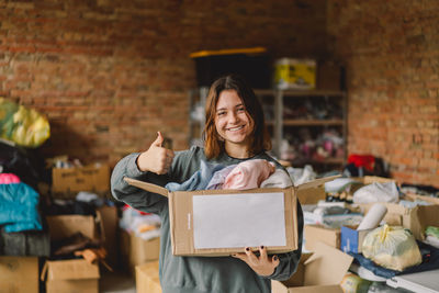 Volunteer teengirl preparing donation boxes for people.