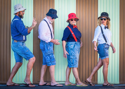 People walking against corrugated wall