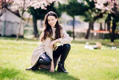 Portrait of smiling young woman sitting on grass