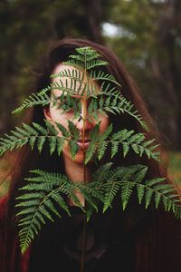 Youn woman holding a fern leaf