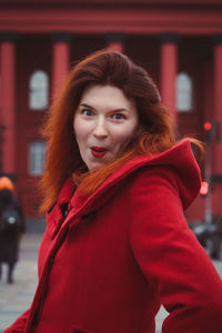 Close up surprised woman in bright coat on street portrait picture