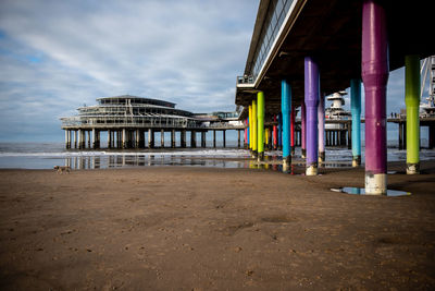 View of pier on beach against sky