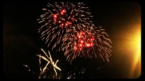 Low angle view of firework display at night