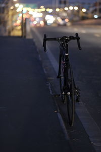 Bicycle parked on street at night