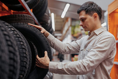 Man choosing tire at store