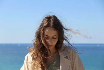 Portrait of beautiful woman against sea against clear sky