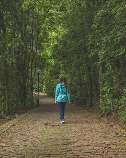 Rear view of woman walking in forest