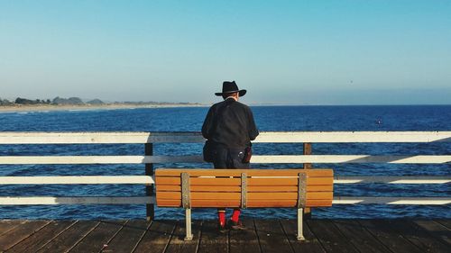 Rear view of woman standing on pier