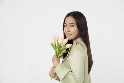 Portrait of smiling woman standing against white background