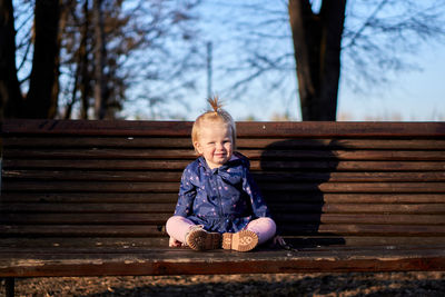 Full length of girl sitting on bench