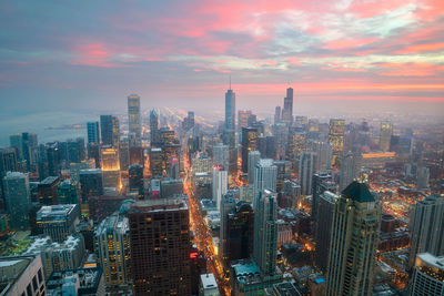 Aerial view of city lit up at sunset