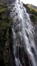 Scenic view of waterfall against sky