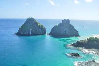 Scenic view of rocks in sea against sky