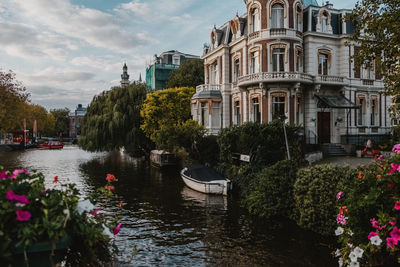 Scenic view of river by buildings against sky