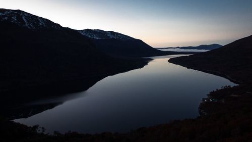 Scenic view of river and mountains against clear sky