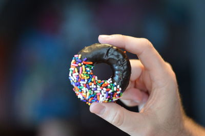Cropped hand holding donut