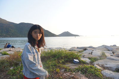 Portrait of young woman in sea against sky