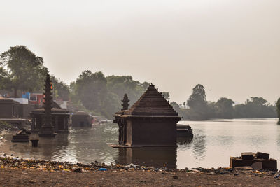 Built structure by lake against clear sky