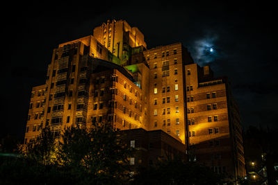 Low angle view of illuminated buildings against sky at night