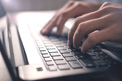 Cropped image of man using laptop