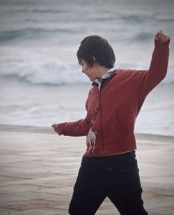 Boy standing against sea