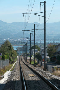 Railroad tracks by mountain against sky