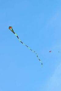 Low angle view of kite flying against clear blue sky