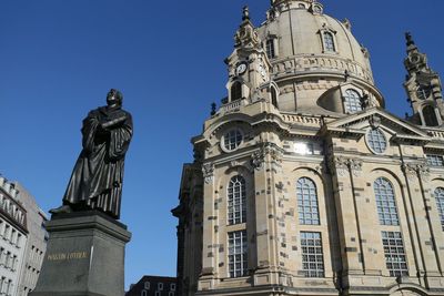 Statue of martin luther in front of church against clear sky