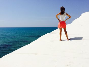 Full length of man standing in sea against sky